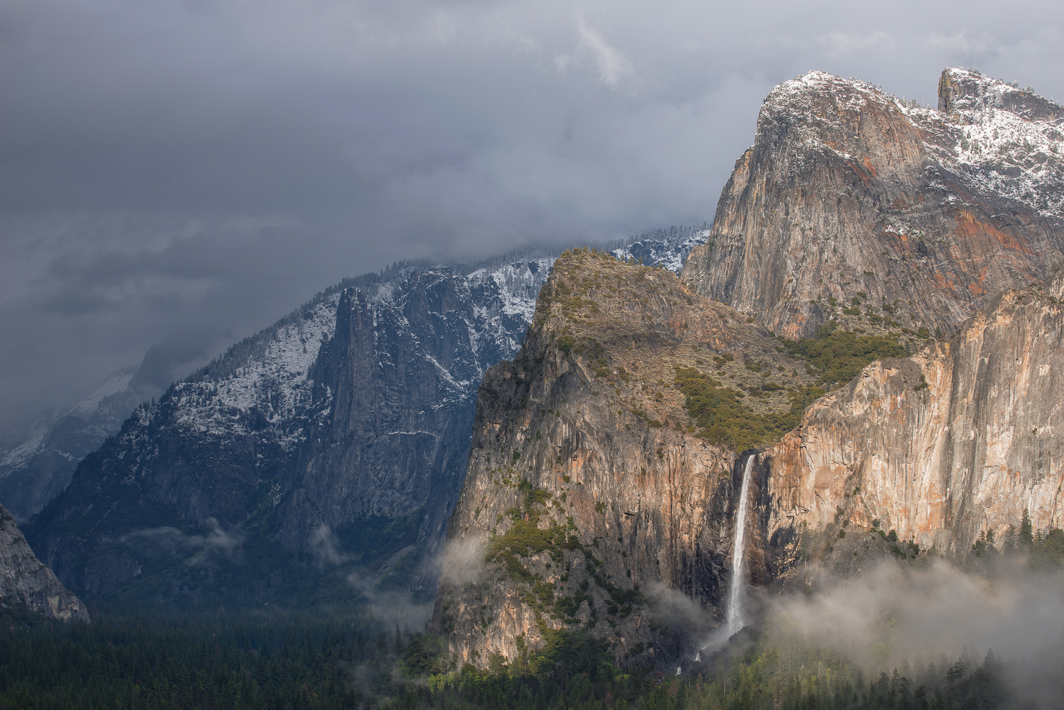 Afternoon light peaks through a passing storm to light up Bridalveil Falls