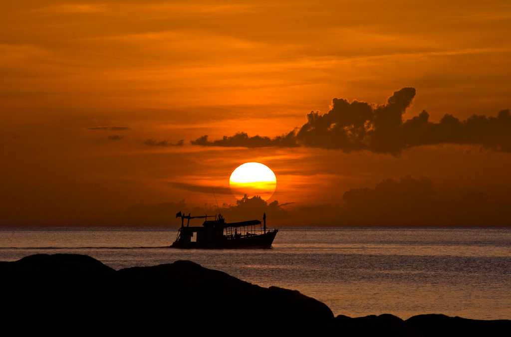 Sunset over a passing dive boat in Koh Tae Island, Thailand