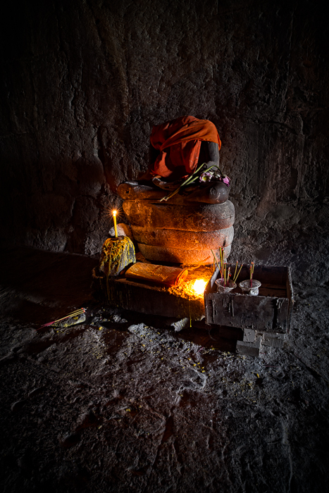 A candle lit shrine to Buddha found in Angkor Wat City in Cambodia