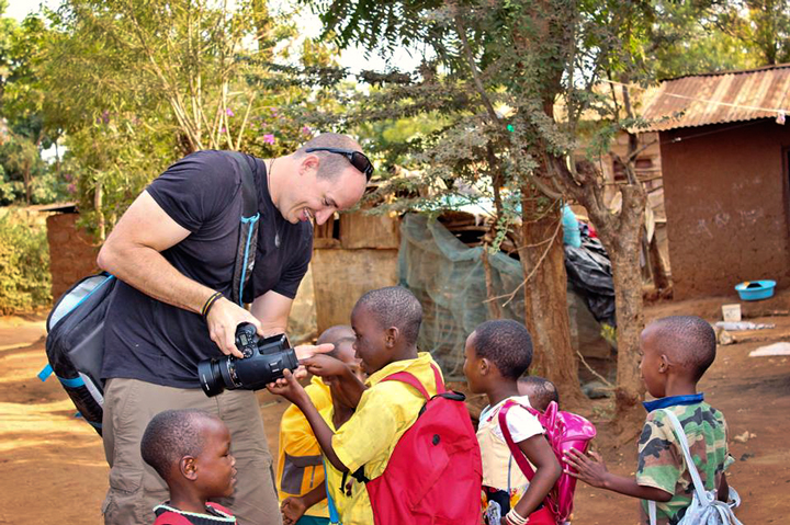 An image of Colby Brown showing Tanzanian kids their photo on the back of a Phase One IQ260
