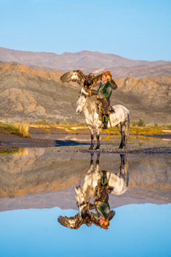 Eagle Hunter captured at a lake with an incredible reflection, Mongolian Photo Workshop Adventure with Colby Brown